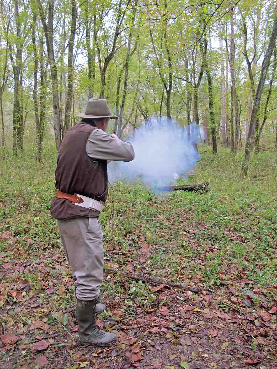 Roscoe Stephenson is shooting the “charging boar”. The target is a milk jug speeding and bouncing toward the shooter. The target is located just above the log almost obscured by the cloud of white smoke from 110 grains of 1½ Fg Olde Eynsford powder from his .45 (3¼). Yes, he hit the target on both runs.
